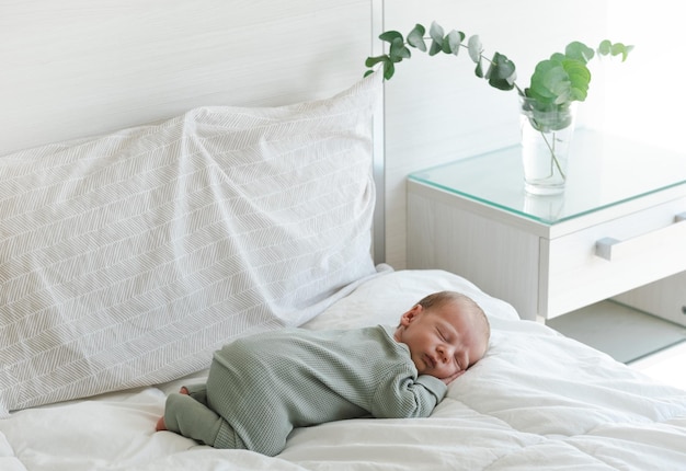 Mignon caucasien plusieurs jours nouveau-né dormant sur une couverture blanche à homeadorablecalm bébé innocent