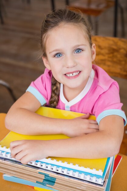 Mignon élève souriant à la caméra dans la salle de classe