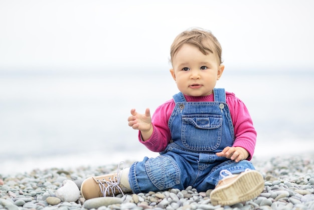 Mignon enfant d'un an jouant sur la plage