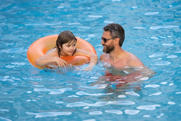 Mignon enfant excité avec papa dans la piscine d'été père et enfant s'amusant dans la piscine d'été fathe