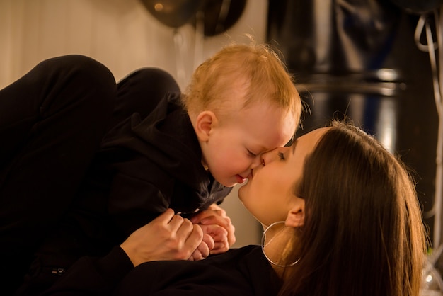 Mignon enfant gai avec la mère joue à l'intérieur.