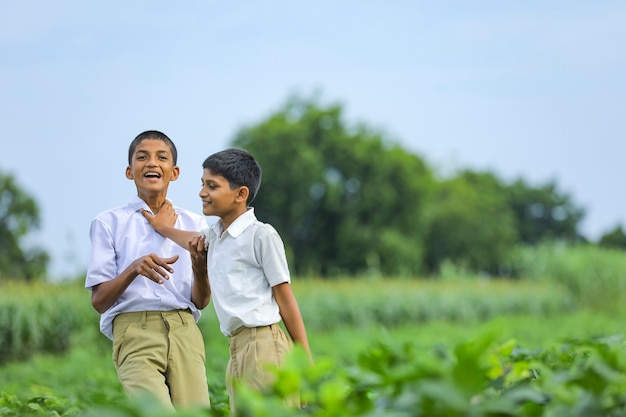 Mignon enfant indien jouant au champ vert