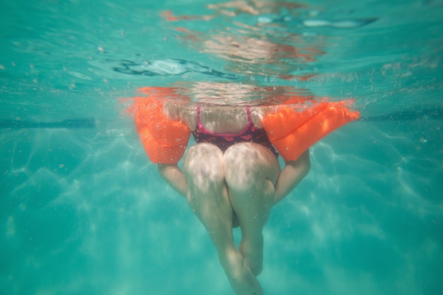 Mignon enfant posant sous l&#39;eau dans la piscine