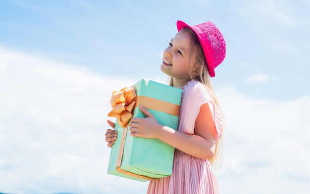 Mignon enfant en robe tenir présent magasin de boîte