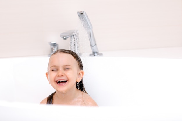 mignon enfant souriant heureux prenant un bain sous le concept de soins de santé et d'hygiène des enfants en cours d'exécution