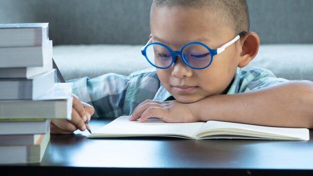 Mignon garçon asiatique écrire des devoirs à la maison. concept d&#39;éducation