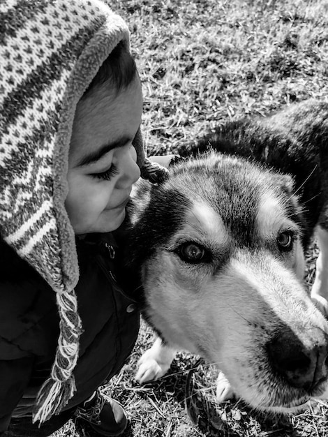 Photo un mignon garçon avec un chien sur le terrain