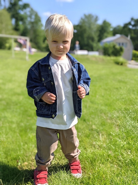 mignon garçon enfant dans une veste en jean dans le parc