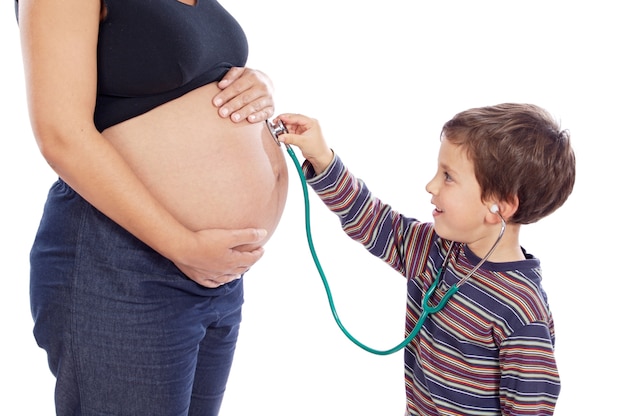 Mignon garçon avec stéthoscope et femme enceinte