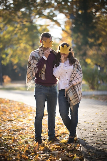 Un mignon jeune couple debout dans le parc d'automne