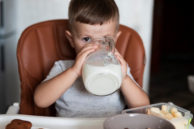 Mignon jeune garçon buvant du lait