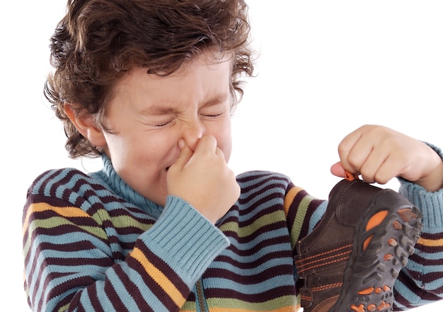 Photo mignon jeune garçon avec une chaussure puante