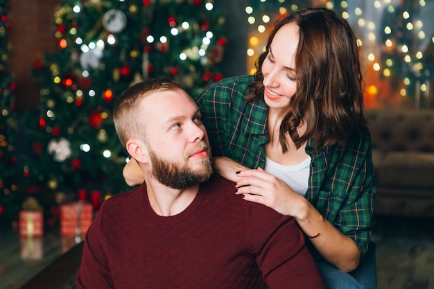 Mignon jeune mari et femme de la famille à l'arbre de Noël