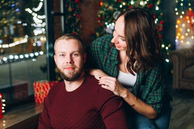 Mignon jeune mari et femme de la famille à l'arbre de Noël