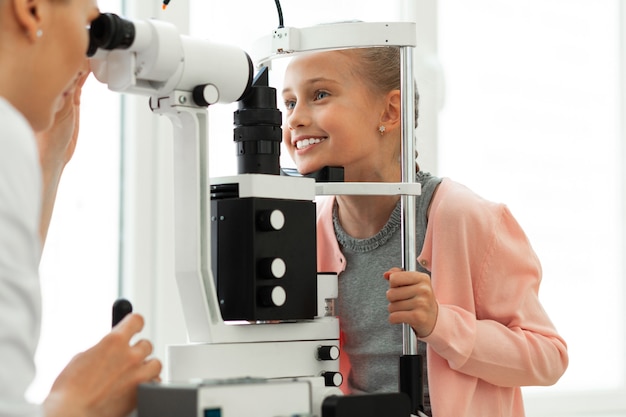 Photo mignon jeune patient aux yeux bleus endurant calmement la procédure