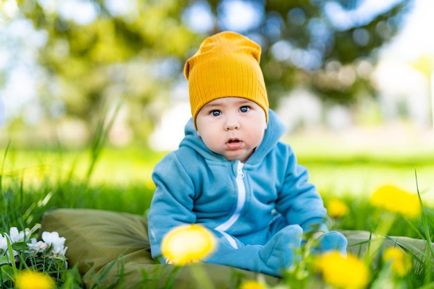 Mignon joli nouveau-né assis sur le jardin Portrait de jeune petit garçon dans la nature