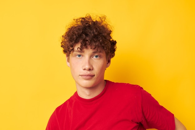 Mignon mec roux t-shirt rouge amusant posant des vêtements décontractés fond isolé inchangé