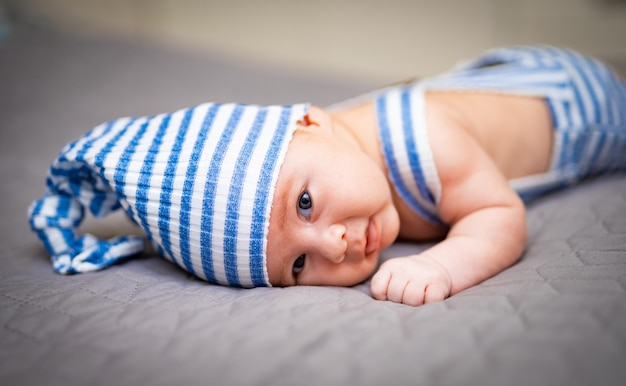 Mignon petit bébé allongé sur le lit Portrait d'enfant souriant