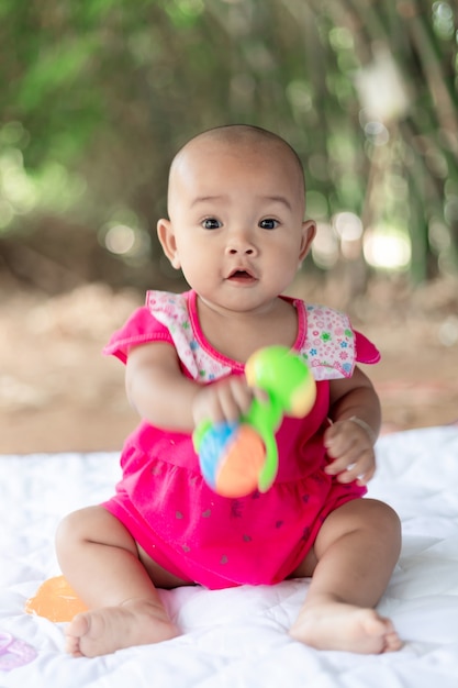 Mignon petit bébé asiatique assis et jouer avec bonheur