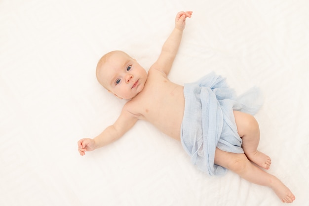 Mignon petit bébé assis dans son lit