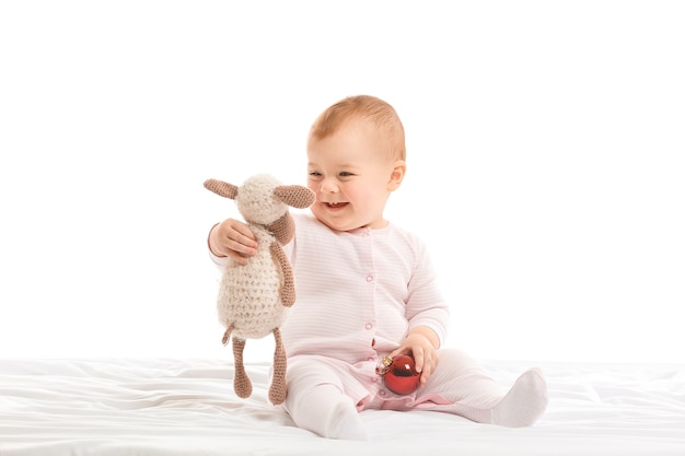 Mignon petit bébé avec ballon et jouet sur sol blanc