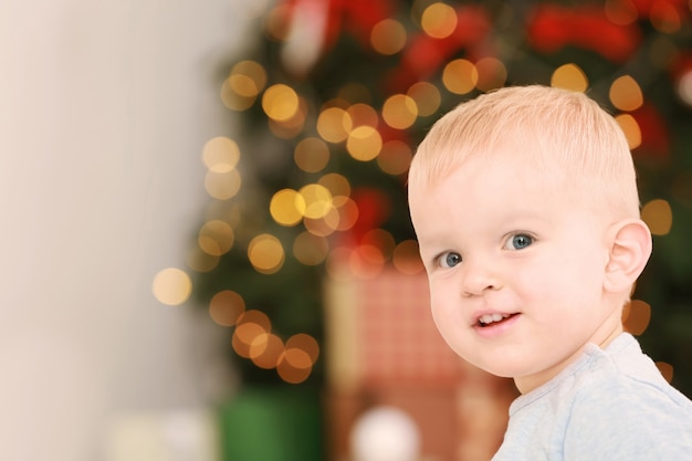 Mignon petit bébé contre les lumières défocalisées. Notion de Noël