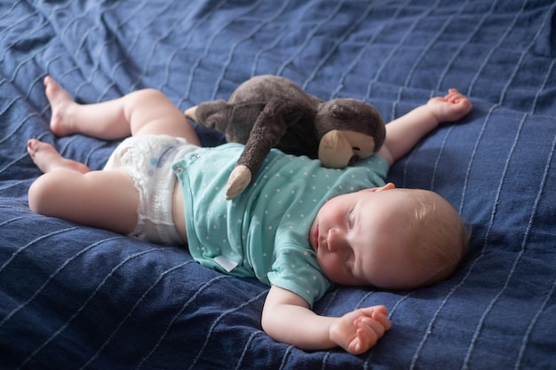 Mignon petit bébé dormant sur le lit à la maison