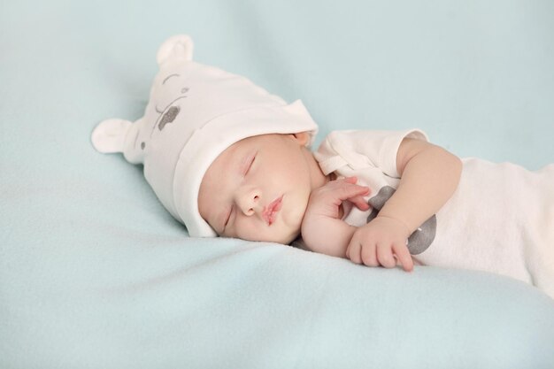 Mignon petit bébé dormant sur le lit à la maison