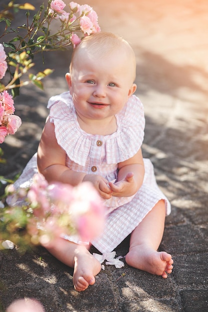 Mignon petit bébé à l'extérieur Jolie petite fille avec des roses joli enfant dans le jardin