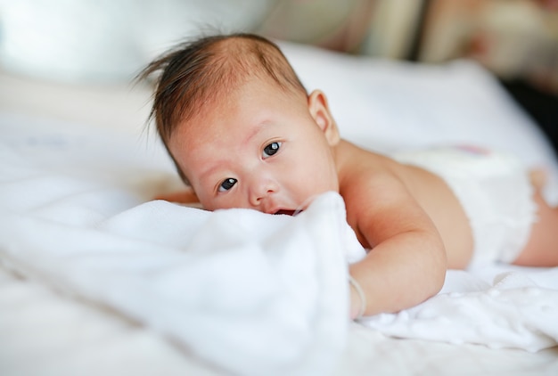 Mignon petit bébé garçon couché sur le lit.