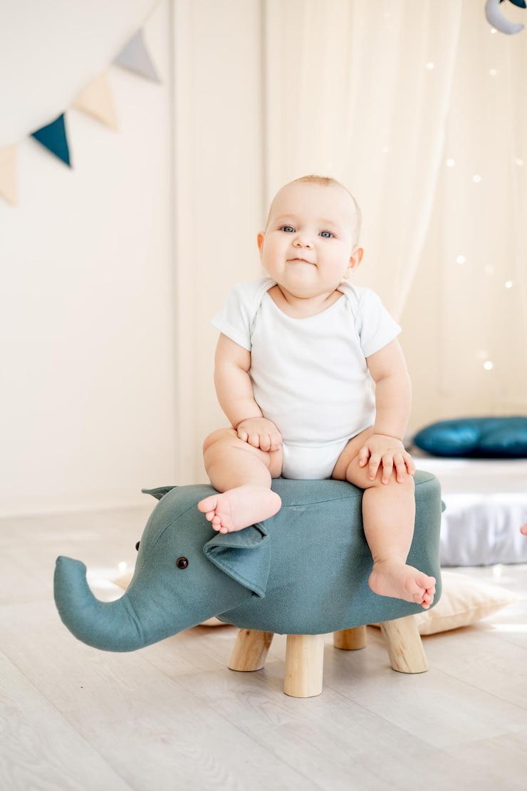 Photo mignon petit bébé garçon dans une chambre d'enfants lumineuse avec un wigwam jouant dans un body en coton et souriant
