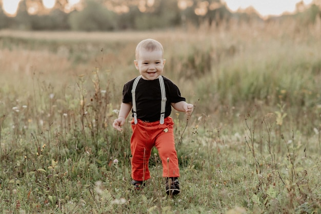 Mignon petit bébé garçon souriant dans le champ d'automne