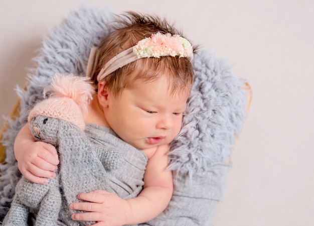 Mignon petit bébé avec lapin jouet tricoté couché