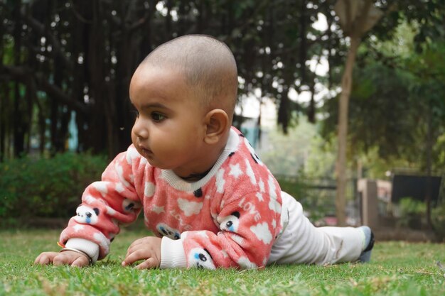 Un mignon petit bébé qui joue dehors dans le champ.