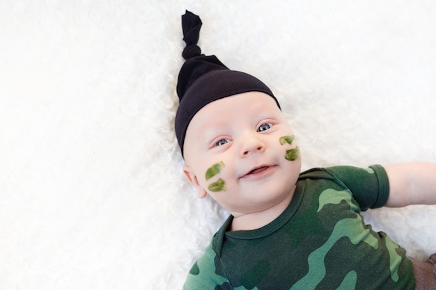 Mignon petit bébé soldat en uniforme. petit garçon en costume de camouflage sur fond blanc