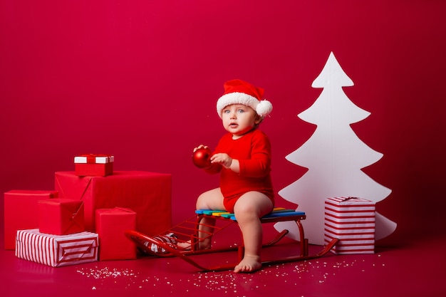 Mignon petit bébé sur un traîneau à Noël