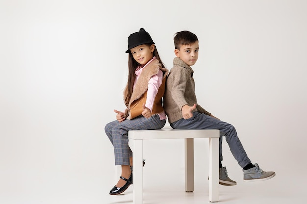 Mignon petit couple élégant enfant fille et garçon assis ensemble