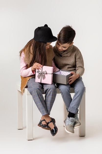 Mignon petit couple élégant enfant fille et garçon assis ensemble