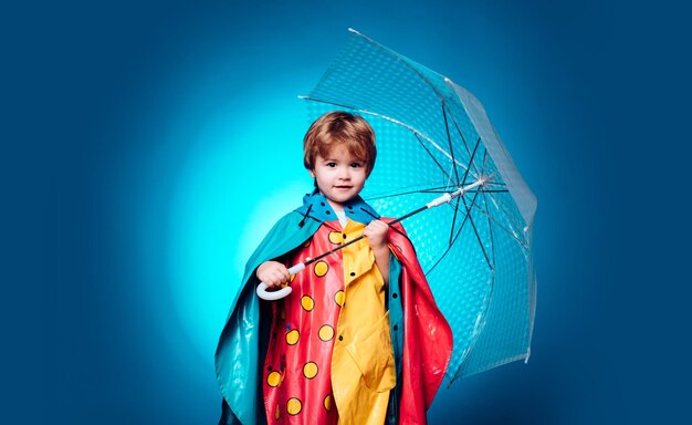 Mignon petit enfant garçon portant des vêtements d'automne le jour de la pluie d'automne Garçon joyeux en imperméable avec parapluie coloré Mignon petit garçon se prépare pour la journée ensoleillée d'automne Enfant sous la pluie