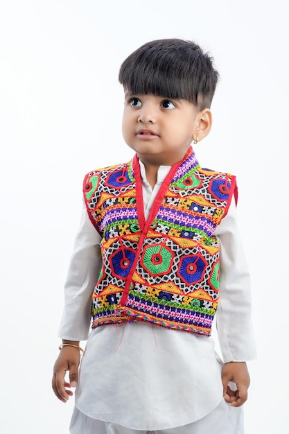 Mignon petit enfant indien en vêtements ethniques et montrant l'expression sur fond blanc