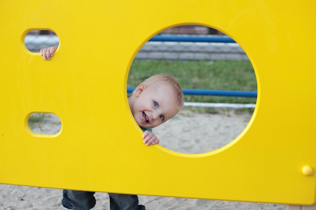 Photo mignon petit enfant jouant sur l'aire de jeux à l'extérieur