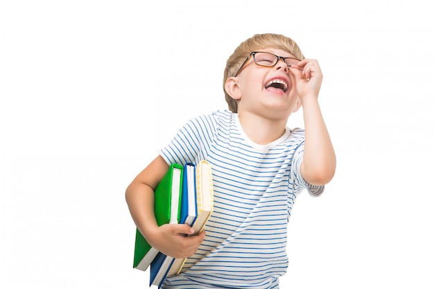 Mignon petit enfant avec des livres et des cahiers Adorable enfant lisant. Tourné en studio d'écolier. Garçon portant des lunettes.