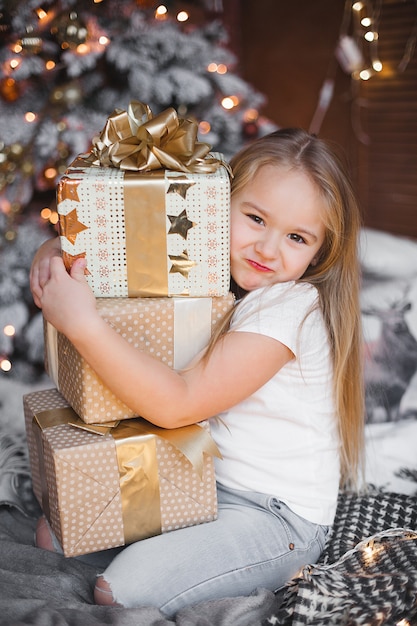 Mignon petit enfant tenant des cadeaux de Noël