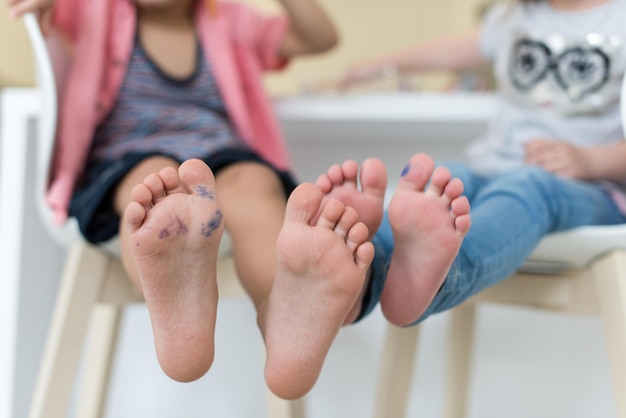 mignon petit frère et soeur à la maison pieds nus dans la cuisine s'amusant