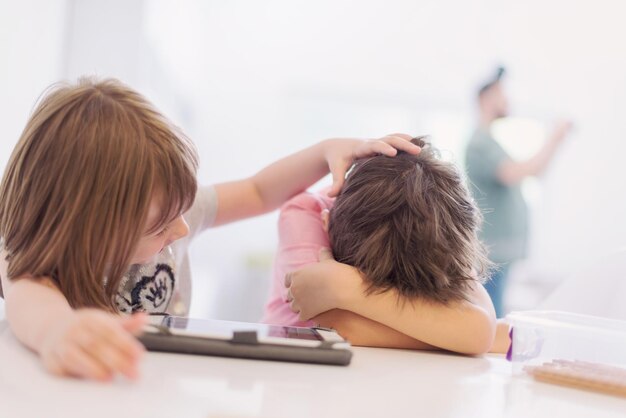 mignon petit frère et soeur s'amusant à la maison des enfants jouant à des jeux sur une tablette