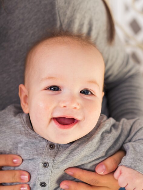 Mignon petit garçon sur bleu riant avec sa mère