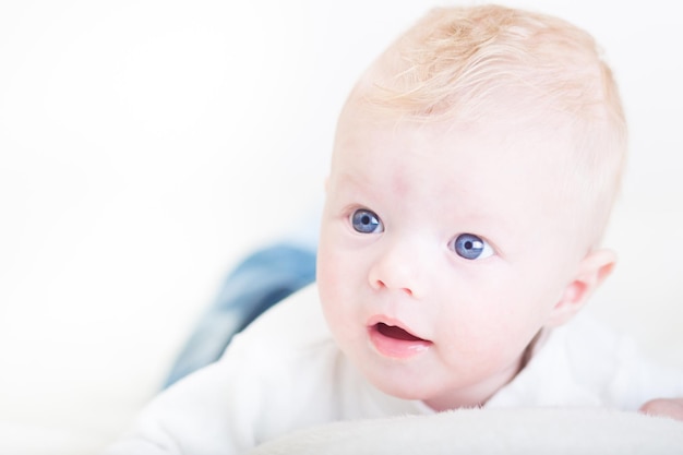 Mignon petit garçon blond aux yeux bleus.