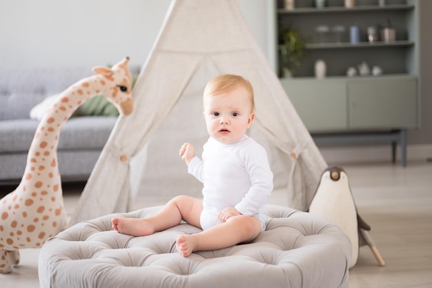 Un mignon petit garçon en bonne santé dans une chambre d'enfant spacieuse et lumineuse à la maison avec un wigwam peluches textiles pour enfants Un enfant joue dans le salon de la maison