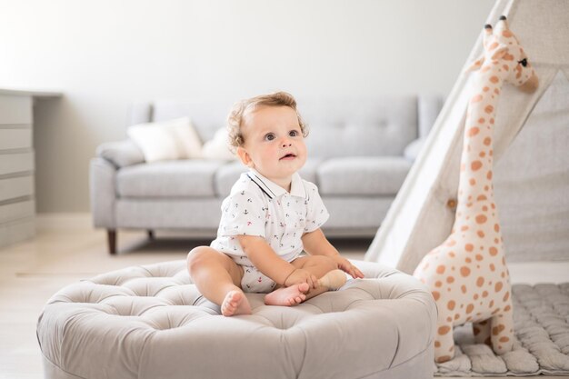 Un mignon petit garçon en bonne santé dans une chambre d'enfant spacieuse et lumineuse à la maison avec un wigwam peluches textiles pour enfants Un enfant joue dans le salon de la maison