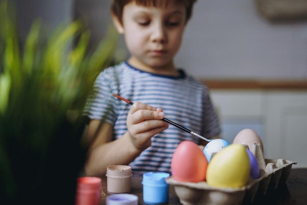 Mignon petit garçon à colorier des oeufs pour Pâques Image avec mise au point sélective